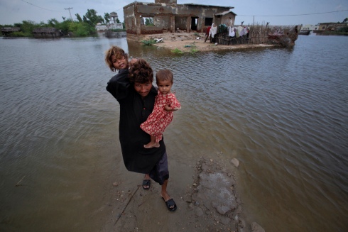 A father carries his daughters to higher ground Image Courtesy of Trust.org