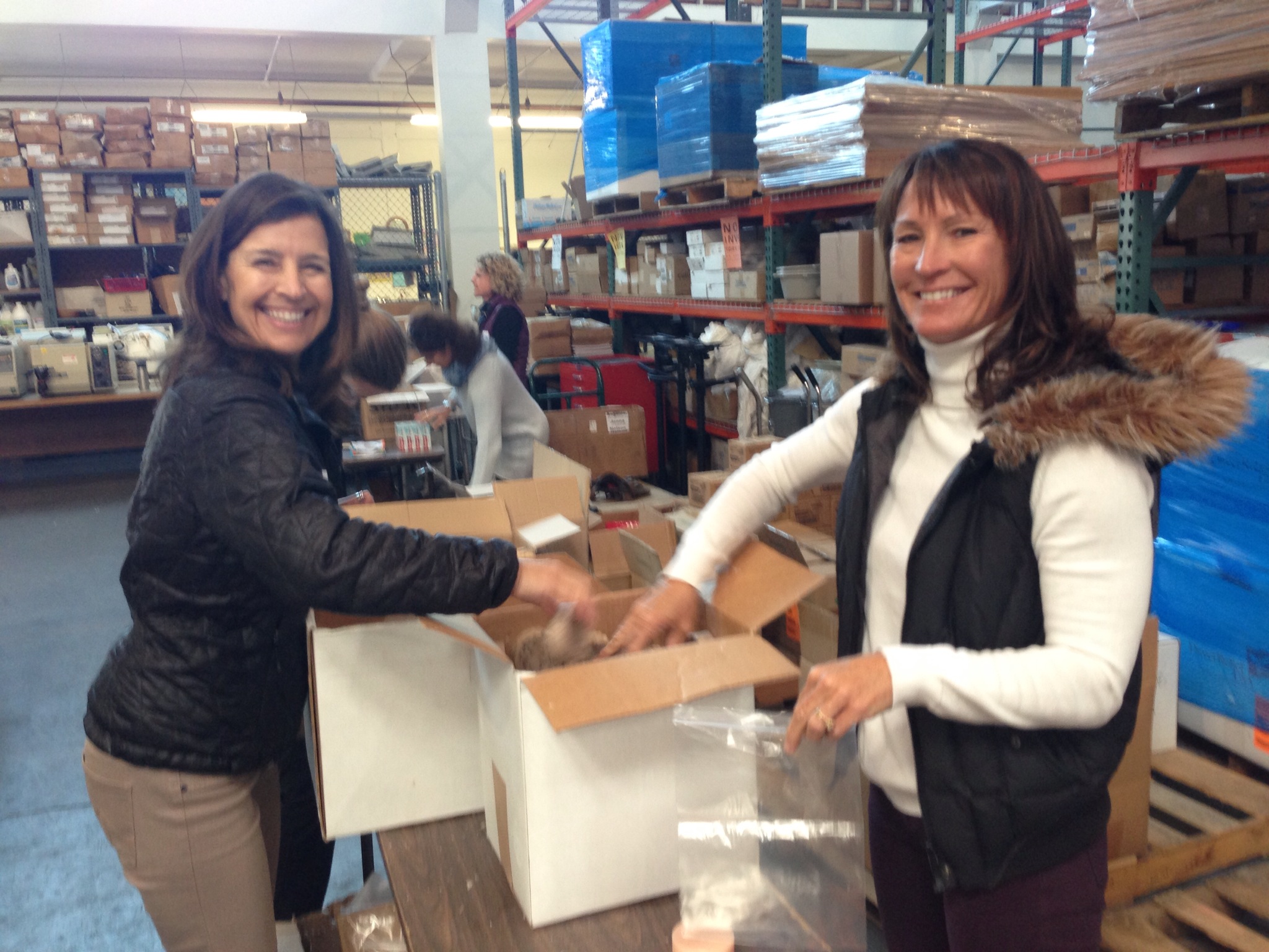 Volunteers smile as they help pack care kits for local women in need.