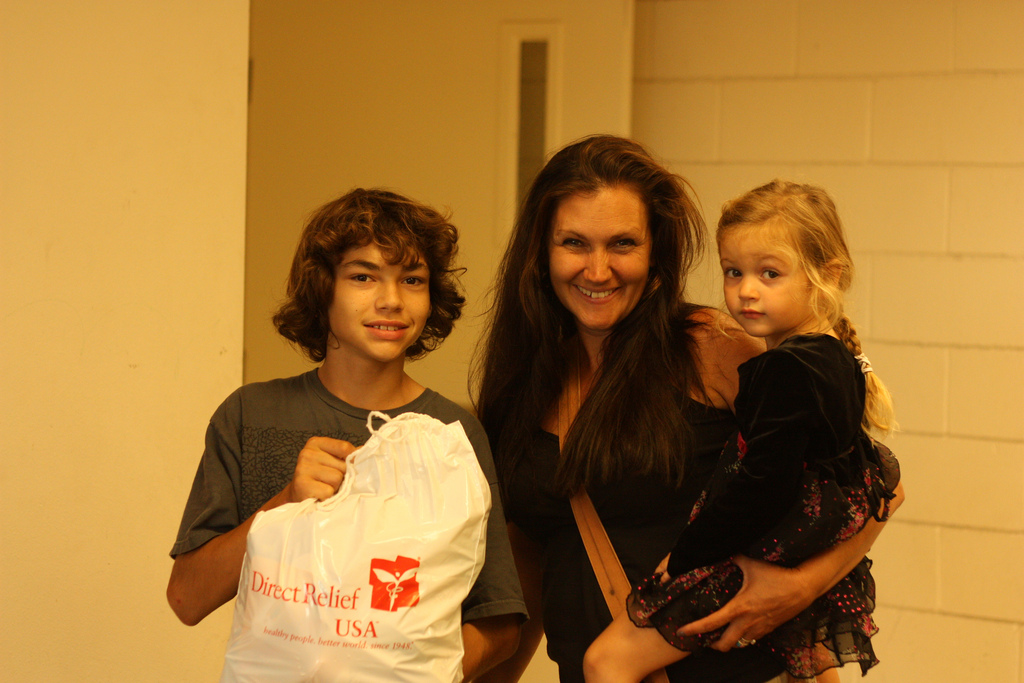 A family smiles after receiving one of our personal care packs given out at Transition House.