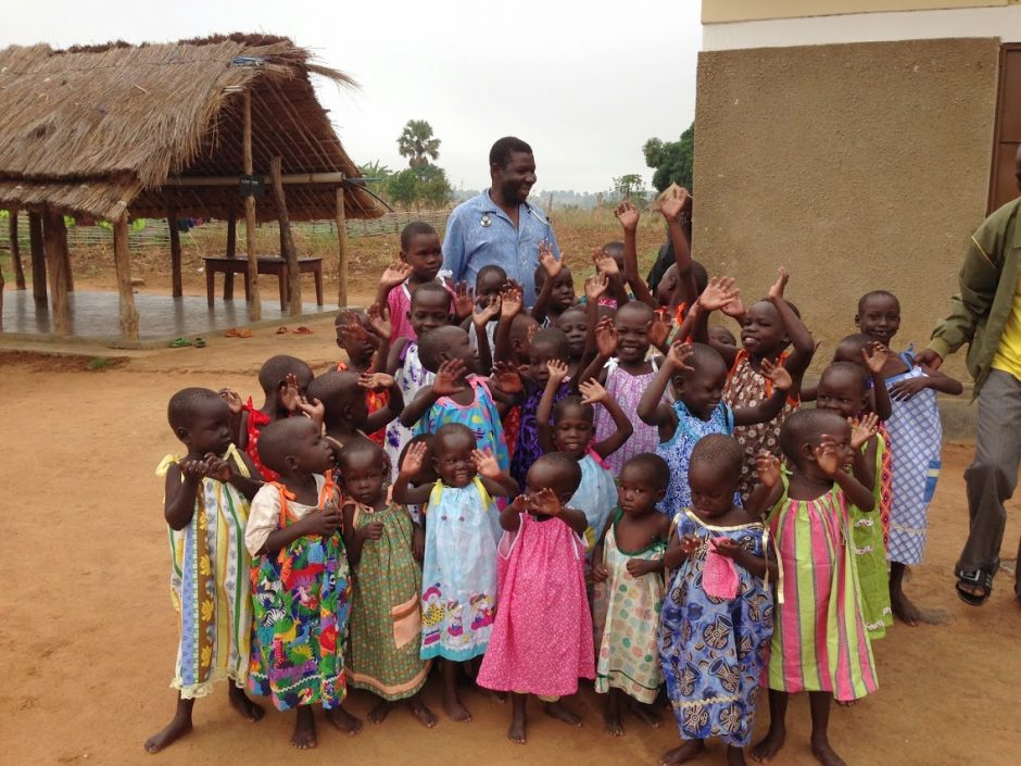 Dr. Jospeh Dumba, the founder of the Healing Kadi Foundation, stands with children in Kajo Keji, South Sudan, in 2014. While the country endures war and famine, Direct Relief is actively supporting medical partners in South Sudan administering critical medical care. (Photo by the Healing Kadi Foundation)