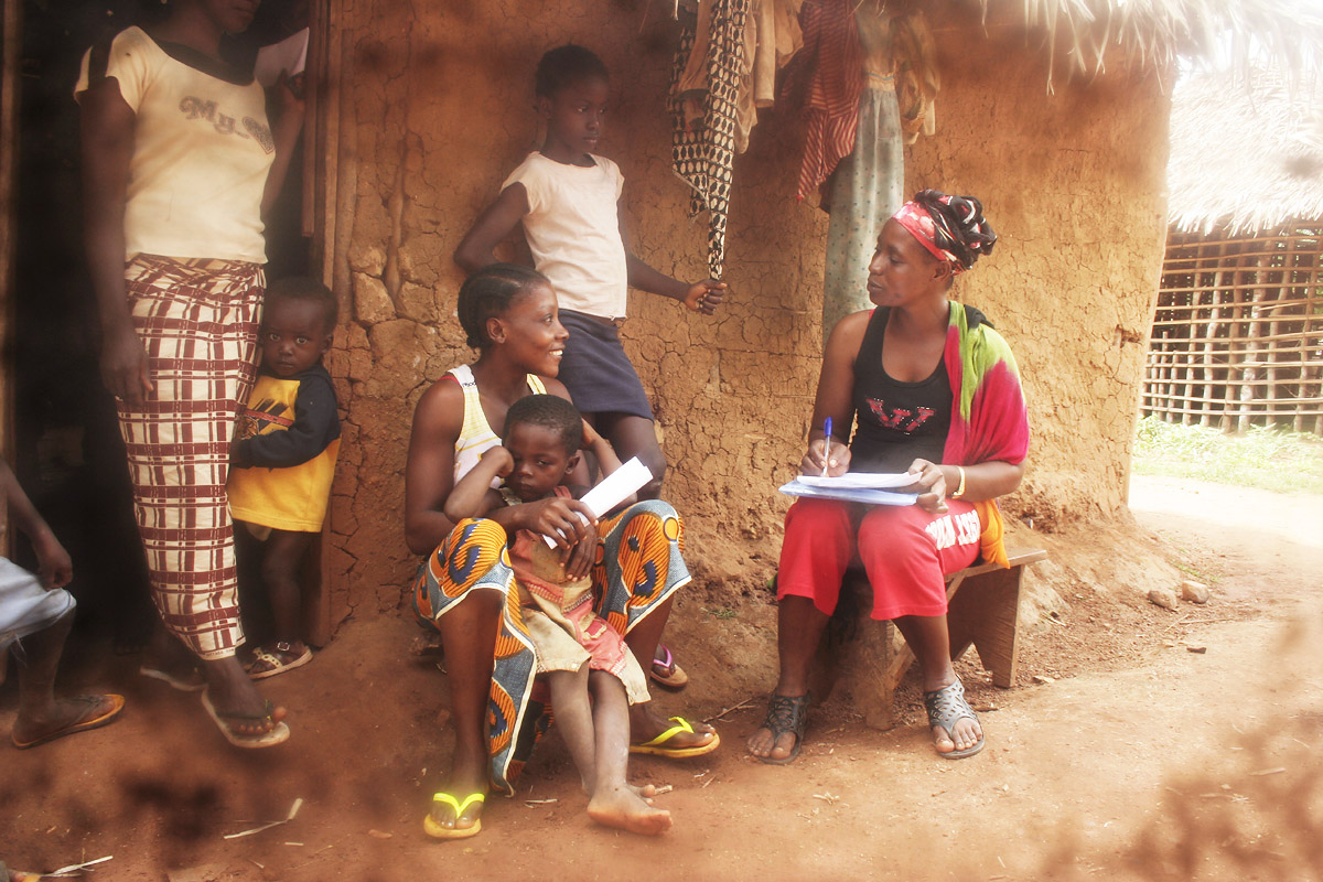 Gracious Nyemah, one of Tiyatien Health's frontline health workers, introducing herself to a potential survey participant in the town of Billibo, Liberia.