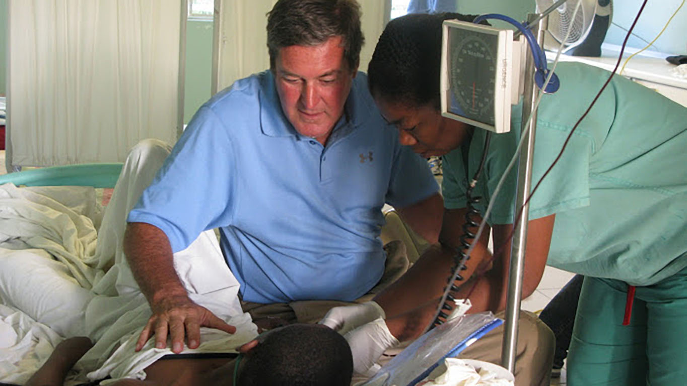 Father Rick Frechette and staff tend to a patient at St. Luke's Hospital in Port au Prince, Haiti. (Photo courtesy of St. Luke Foundation)