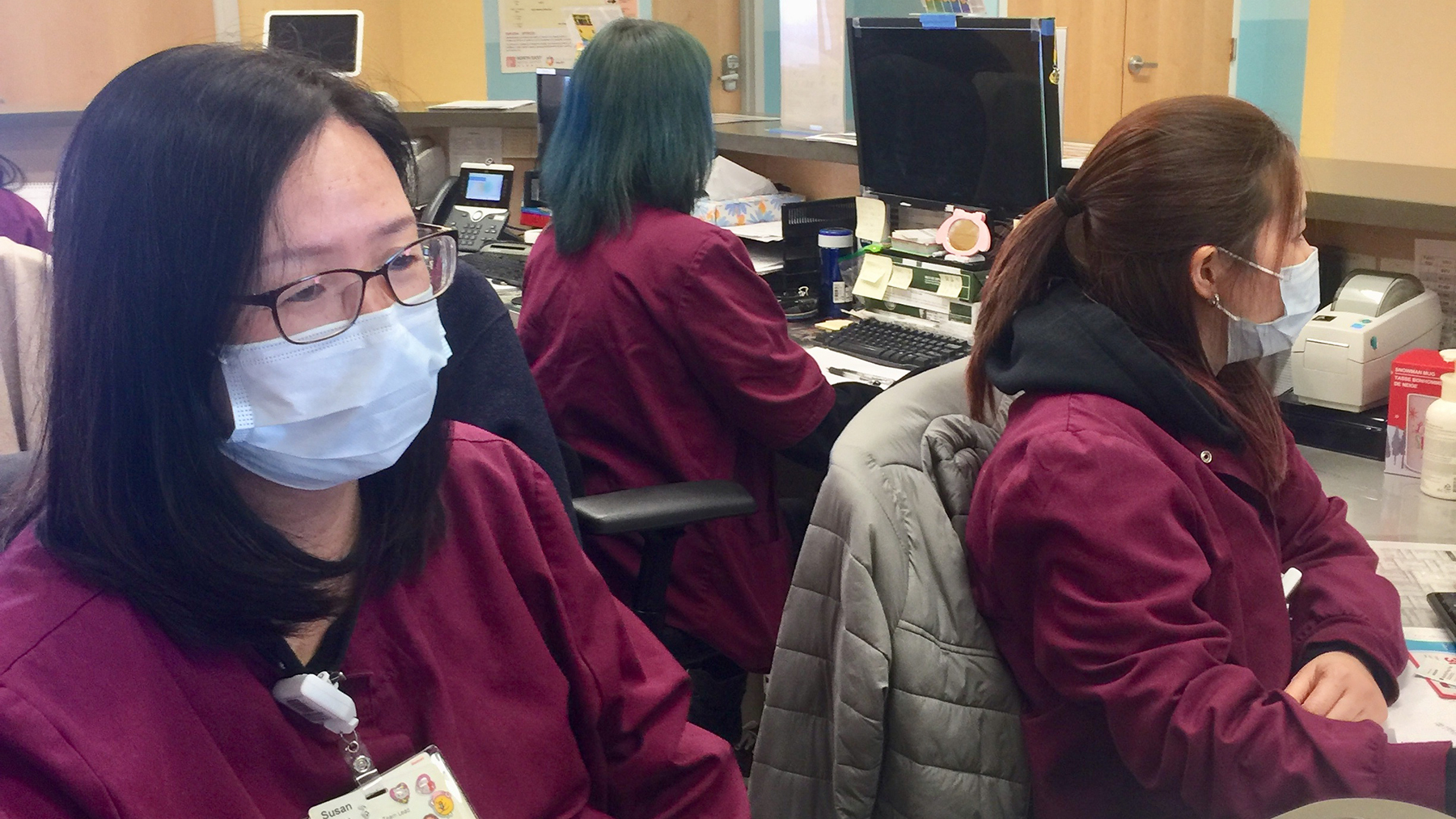Front desk staff at North East Medical Services in the Bay Area wear masks as a protective measure during the coronavirus outbreak. (Photo courtesy of Dr. Kenneth Tai)