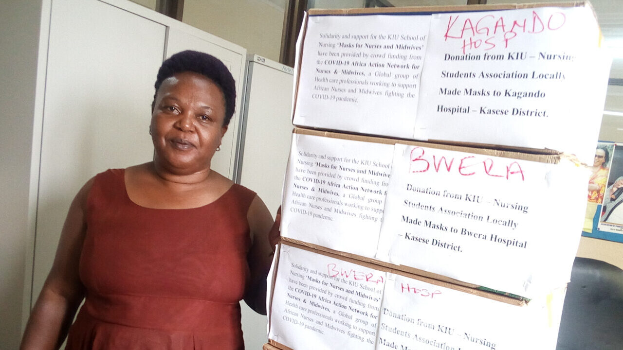 Annet Kabanyoro, head of the nursing school at Kampala International University, in front of masks she and her students helped make. (Photo courtesy of Annet Kabanyoro)