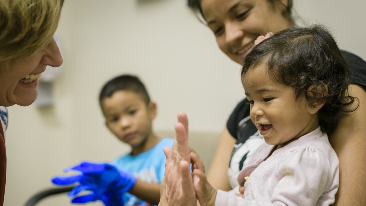 A doctor gives a young patient a "high five"