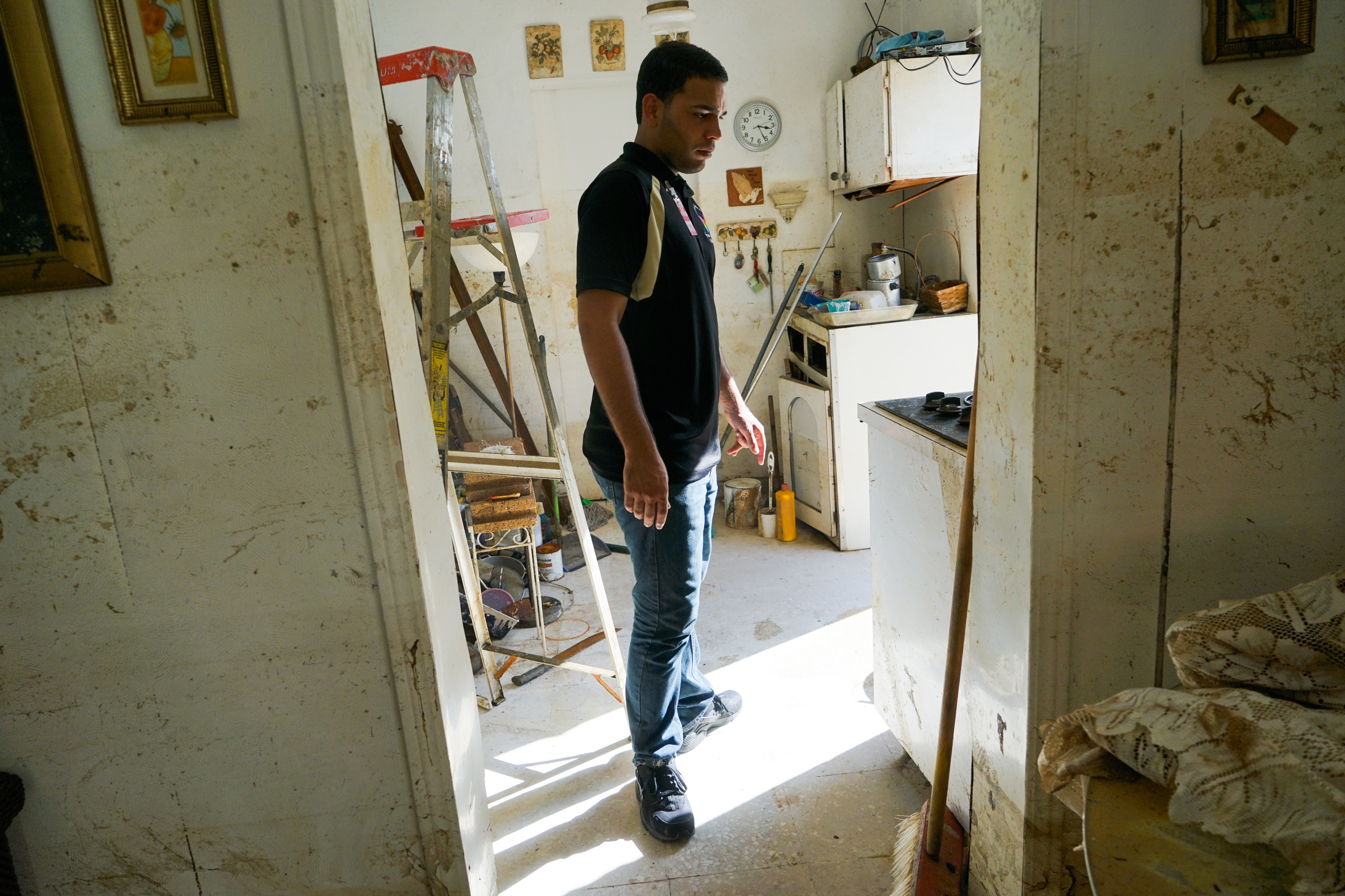 Florida Medical Center employees walk through a home in the Parcelas Selgas neighborhood of Florida, Puerto Rico, where water lines up the walls indicate where storm waters rose. The entire first story of the home was swamped when Maria made landfall. The standing water in the neighborhood worries doctors, who fear GI illness and mosquito-borne disease will increase. (Lara Cooper/Direct Relief)