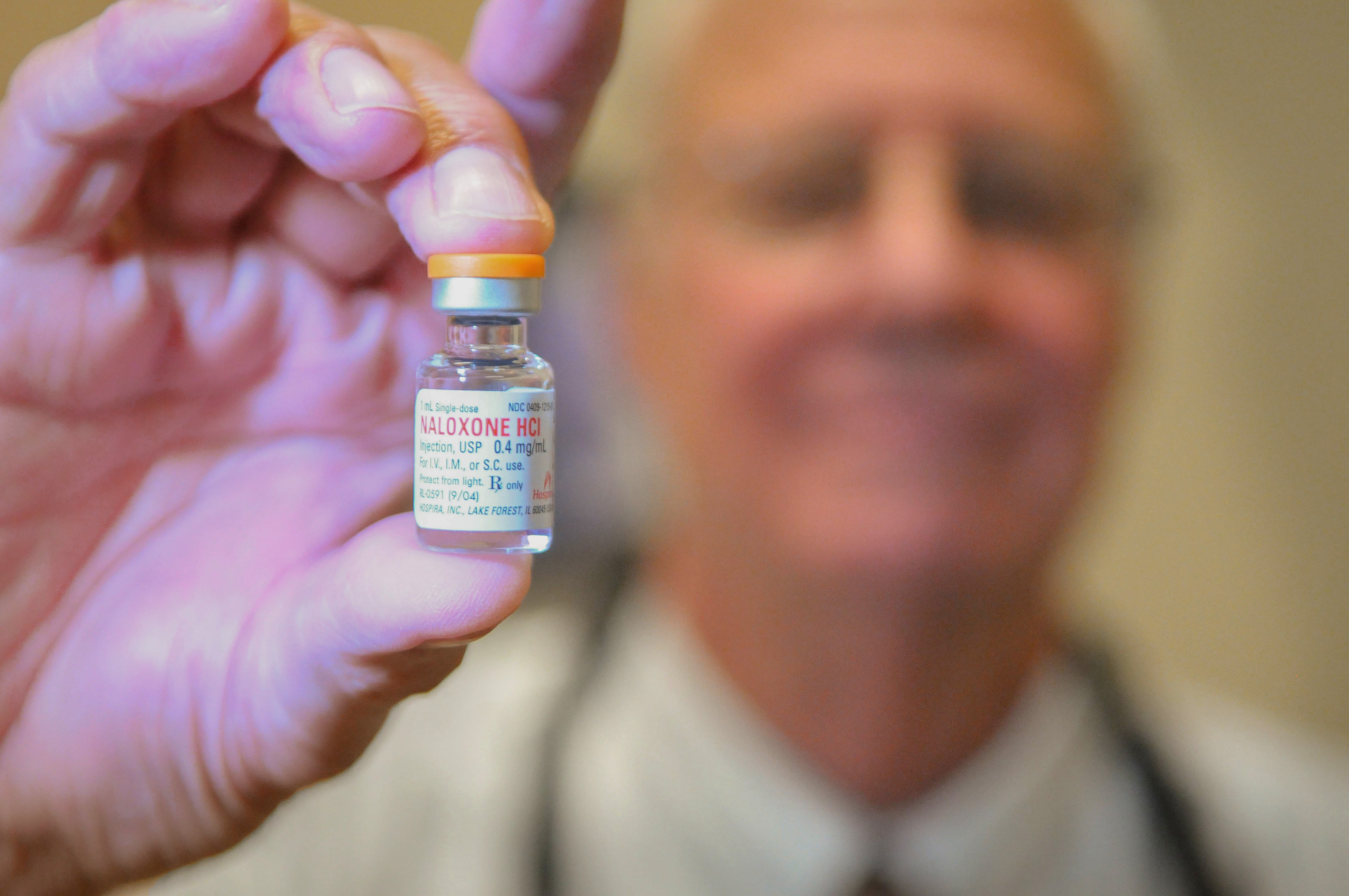 Dr. Charles Fenzi holds up a vial at the Goleta Neighborhood Clinic.